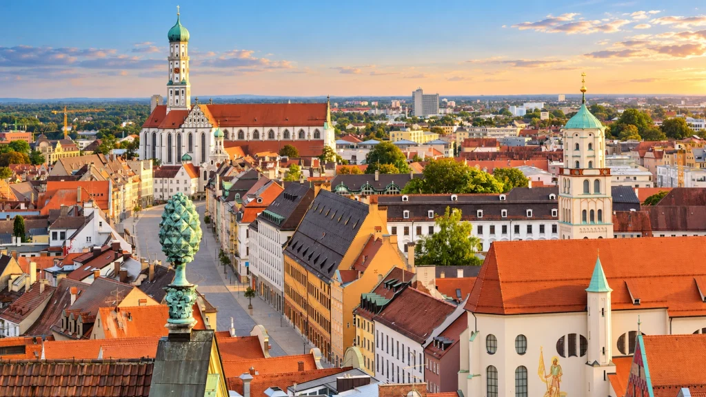 Altstadt von Augsburg mit Maximilianstraße, Bürgerhäusern und Kirchtürmen im warmen Abendlicht