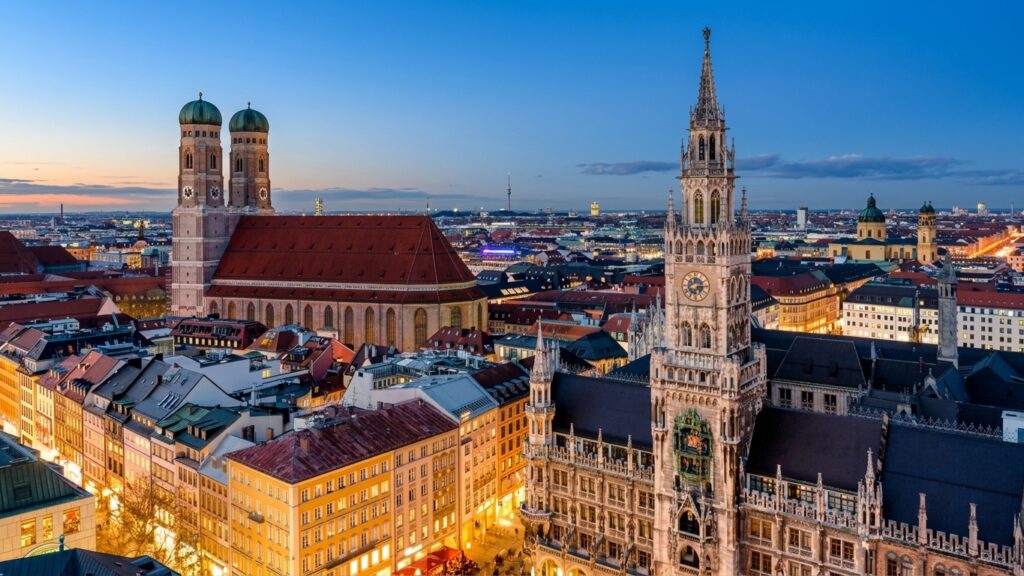 Blick von oben auf den Marienplatz in München mit dem Neuen Rathaus und den Türmen der Frauenkirche in der Abenddämmerung