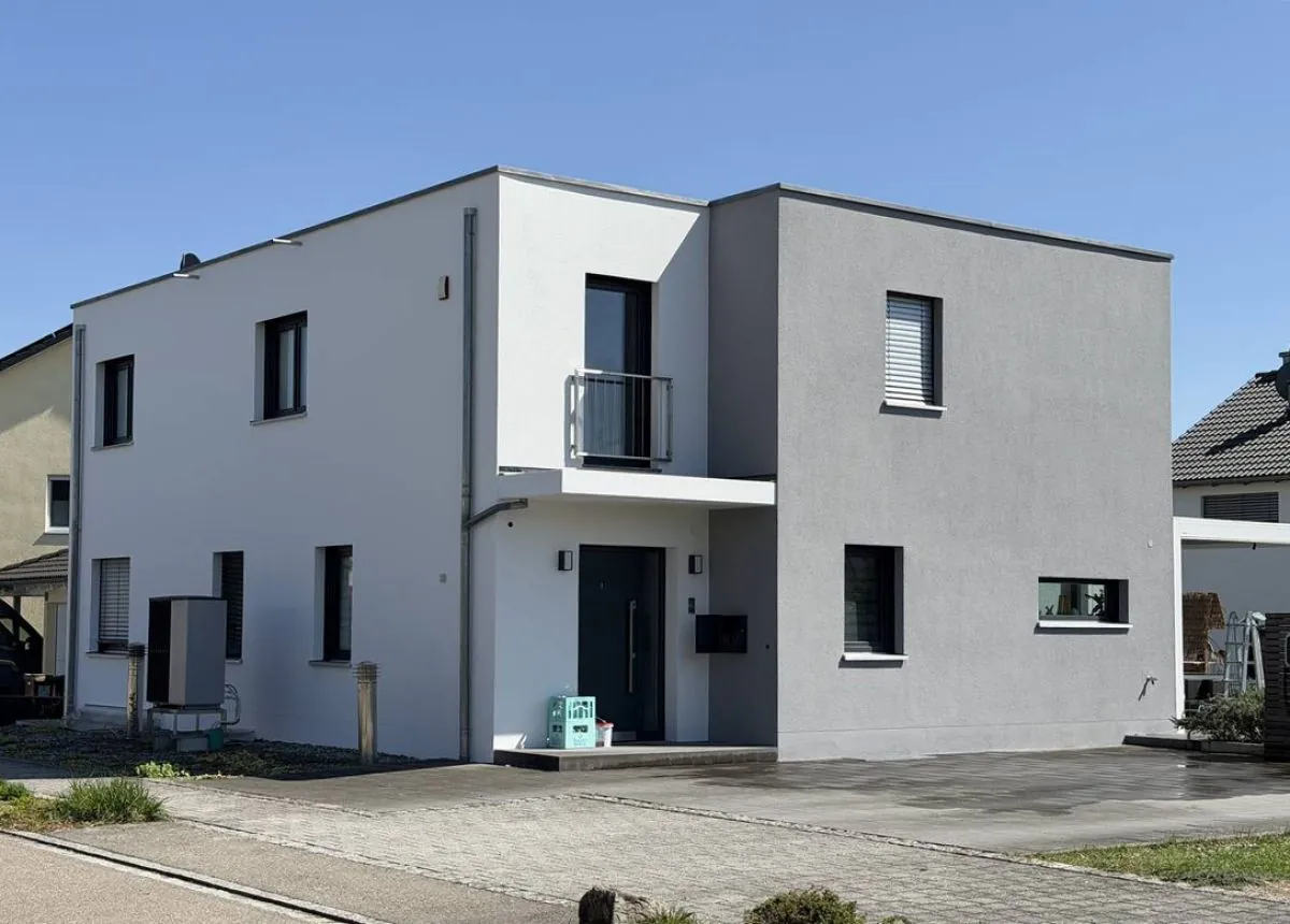 Dieselbe Fassade nach der Sanierung durch AY-Tech Bau: geschlossene, gleichmaessige Oberflaeche in zwei Farbtoenen